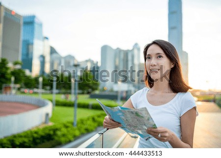 Woman using city map in Hong Kong at evening