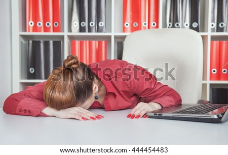 Tired businesswoman sleeping on the table in office