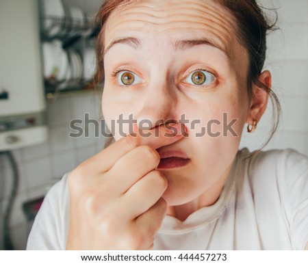 Portrait of a young woman holding her nose because of a bad smell.