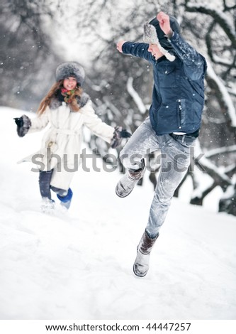 Young couple playing outdoors. Winter season.