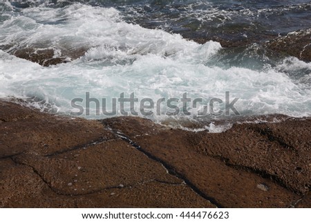 tidal waves on the rocks with foam