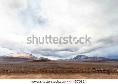 Dirt road on the Andes mountains (Chile) with San Francisco volcano on background