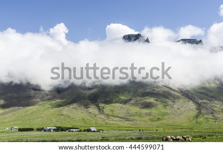 Icelandic mountain in clouds, summer sunny day.