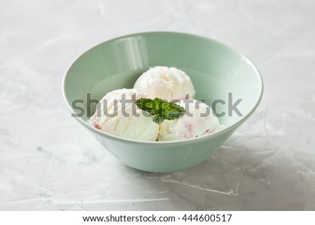 ice cream with strawberry sauce in a bowl on a table, selective focus