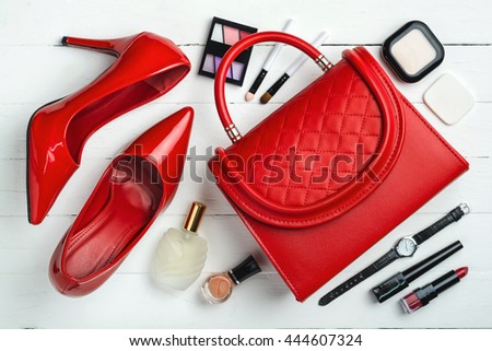 Overhead view of essential beauty items, Top view of red leather bag, red shoes and cosmetic Royalty-Free Stock Photo #444607324