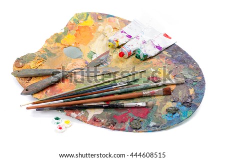 Artist palette with various colors tubes of oil paints and brushes isolated on white background