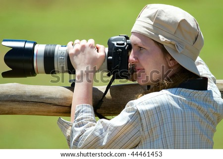 Safari vacation. Professional female photographer taking picture on safari