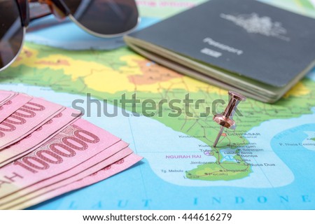 Map of Bali with pin pinned to Kuta area and other travel objects, money, passport and sunglasses. Royalty-Free Stock Photo #444616279