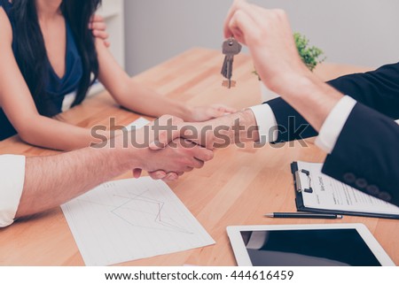Close up photo of handshake. Broker giving keys of new  house
