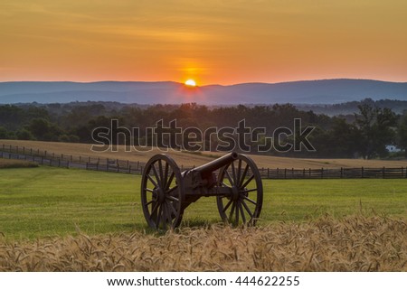 Sun rising behind artillery near a wheat field at Antietam National Battlefield in Sharpsburg, Maryland. The battle at Antietam was the bloodiest single-day battle in American history. Royalty-Free Stock Photo #444622255