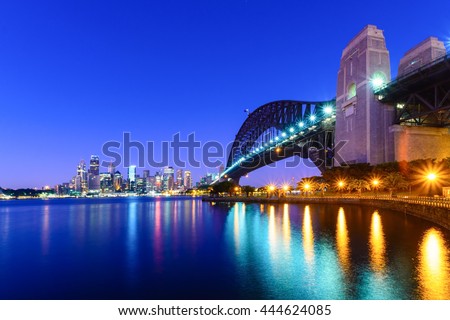 A view of Sydney Harbour Bridge looking towards the city at sunrise.