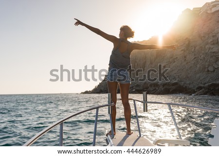 Young woman in the boat at sunset near the rock formations around the Arch in Cabo San Lucas, Mexico. Royalty-Free Stock Photo #444626989
