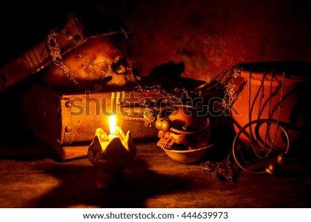 Skull and candle with candlestick on wooden background, still life concept