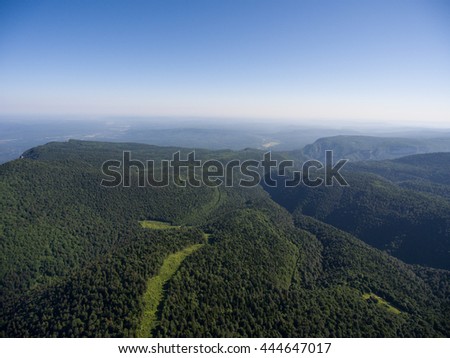 Photos from the bird's-eye view. The mountain ridge covered forest. The road in the forest. Mountain landscape. Caucasus.