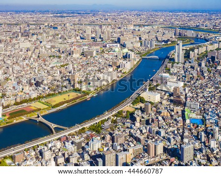 beautiful top view of tokyo city with building, road, bridge, river, trees and moutain in the background