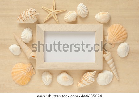 Picture frame with starfish and shell on wood background
