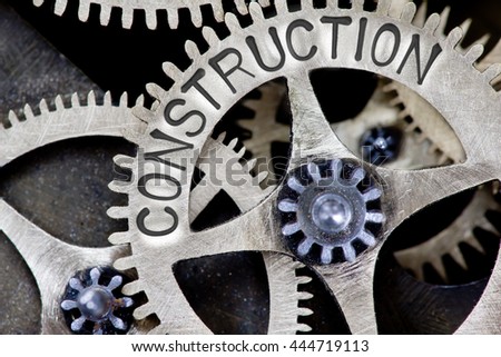 Macro photo of tooth wheel mechanism with CONSTRUCTION concept letters
