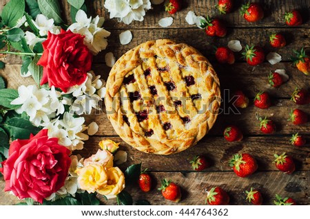 Homemade cherry and strawberry  pie on rustic background. Rustic dark style. decorated with roses and jasmine flowers. Dessert for the family