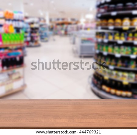 Wooden board empty table in front of blurred background. Perspective dark wood over blur in supermarket - can be used for display or montage your products. Mock up for display of product.