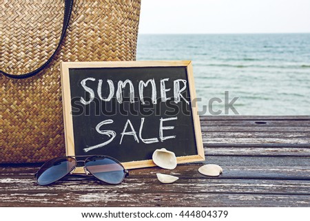 summer sale decorate with bamboo bag and chalkboard on wooden floor on the blue sea ,summer holiday travel and shopping concept.