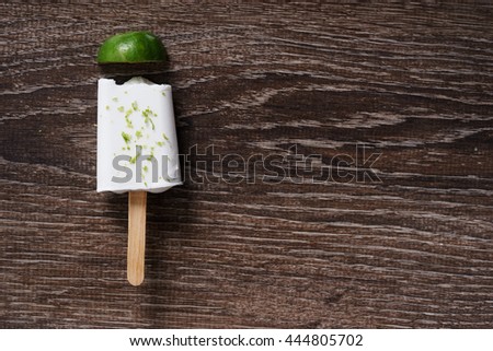 coconut ice pops ,coconut ice cream bar, with fresh green lime zest on wooden background