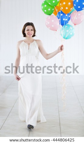 Happy pregnant woman with colorful balloons