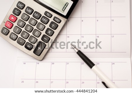 Calculator and pen  and calendar background