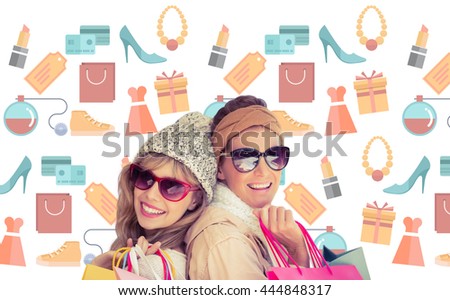 Beautiful women holding shopping bags looking at camera against digital image of shopping doodles