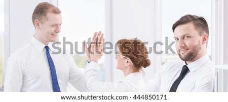 Panoramic picture of colleagues giving each other a high five