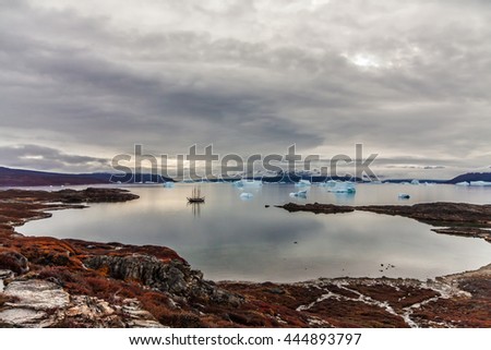 Icebergs and a schooner floating around in the bay, Greenland.