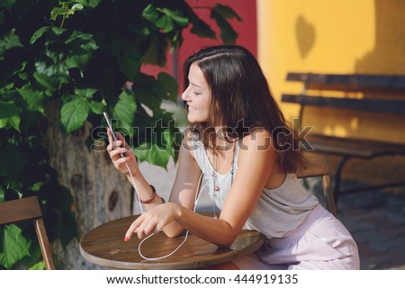 young beautiful woman read a massage on a smart phone and listening music