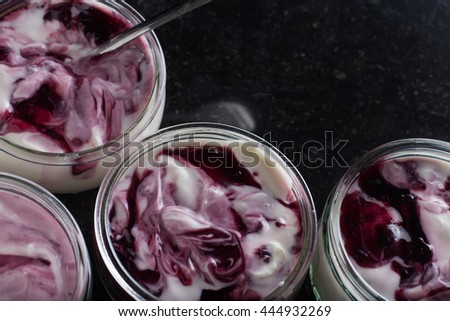 Yogurts with fruits assortment in glass bowls on dark marble background. Natural and fruit healthy, diet, gourmet dessert for granola breakfast. Sweet yoghurts closeup.