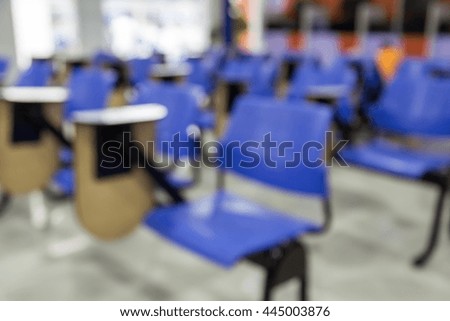Defocus of tables and blue chairs in empty classroom background