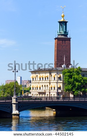 Old red brick church on blue water under blue sky