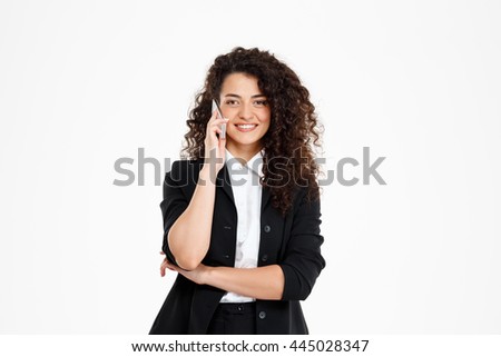 Picture of cheerful curly business girl talking on her phone over white background