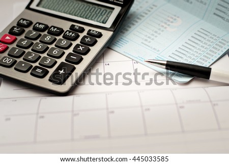 Calculator and pen on a passbook and calendar background Royalty-Free Stock Photo #445033585