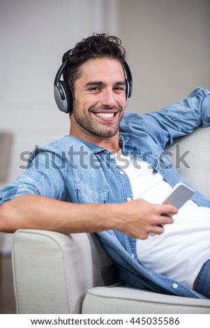 Portrait of handsome man listening to music at home