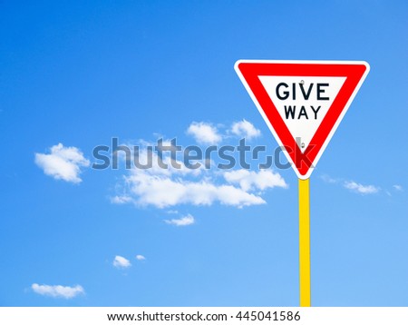 Give way sign on blue sky background (with clipping path)