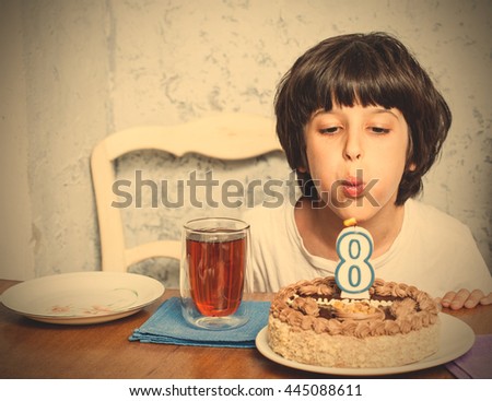 boy blowing out candles on birthday cake. digital eight. eight birthday. celebration. instagram image filter retro style