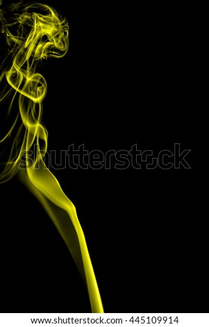 Abstract yellow smoke on black background from the incense sticks
