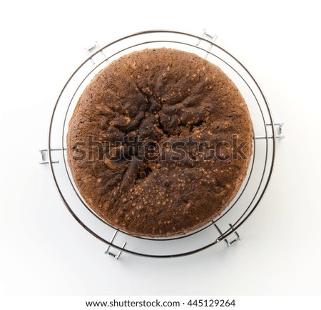 Chocolate Sponge Cake placed on metallic grill. Isolated. Top view.