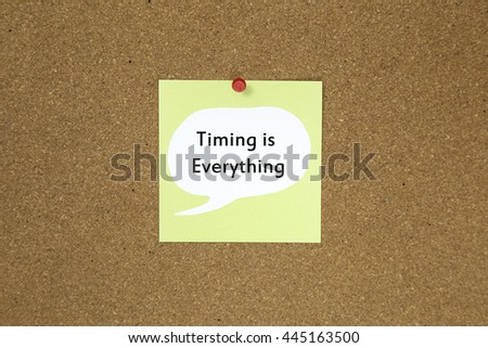 The phrase timing is everything on a green sticky note posted to a cork notice board