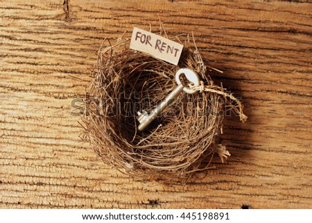 bird's nest on old wood texture with tag paper and wording for rent,old key in bird's nest