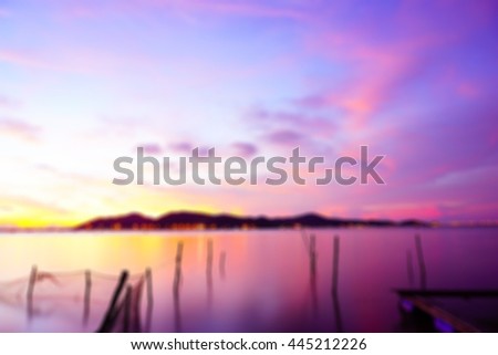 Abstract background blurry image of lake view on evening time after sunset with,silhouette island and fishing net in lake select focus with shallow depth of field:ideal use for background.