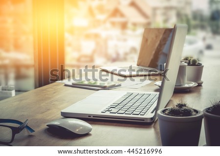 mouse and two laptop on wooden desk in office with morning light. vintage filter effect.selective focus.relax concept.