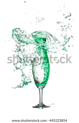 Drink green splash out of glass on a white background.
