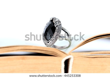 fashion ring with black gem on an old book