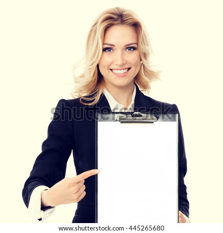 Portrait of young businesswoman showing blank clipboard, with copyspace area for text or slogan