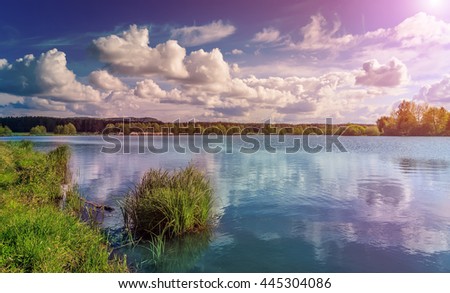 Grass and lake during sunset. Beautiful natural landscape. dramatic sky. Fantastic views of the Lake in the forest. under sunlight. Dramatic and picturesque scene. artistic images. beauty of the world