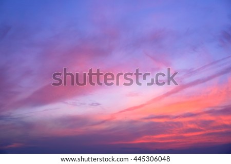 Dark blue sky with red coral streaks shining throughout clouds. Cloud art. Dark tone picture